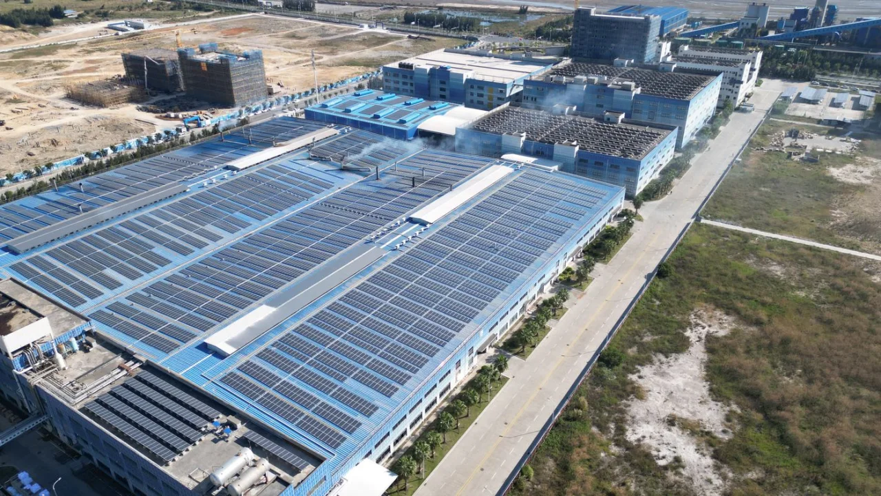 Aerial photograph of an industrial complex with extensive rooftop solar arrays